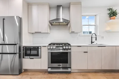 a kitchen with stainless steel appliances granite countertop a stove a refrigerator and a sink
