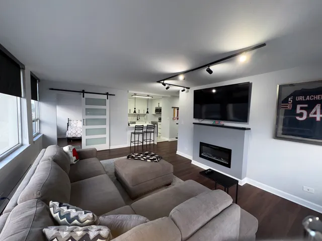 a kitchen with stainless steel appliances kitchen island granite countertop a table chairs and a wooden floor