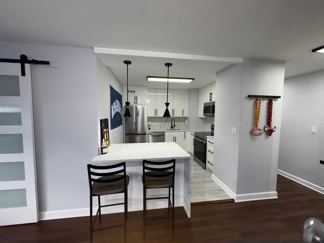 a kitchen with a refrigerator stove and white cabinets