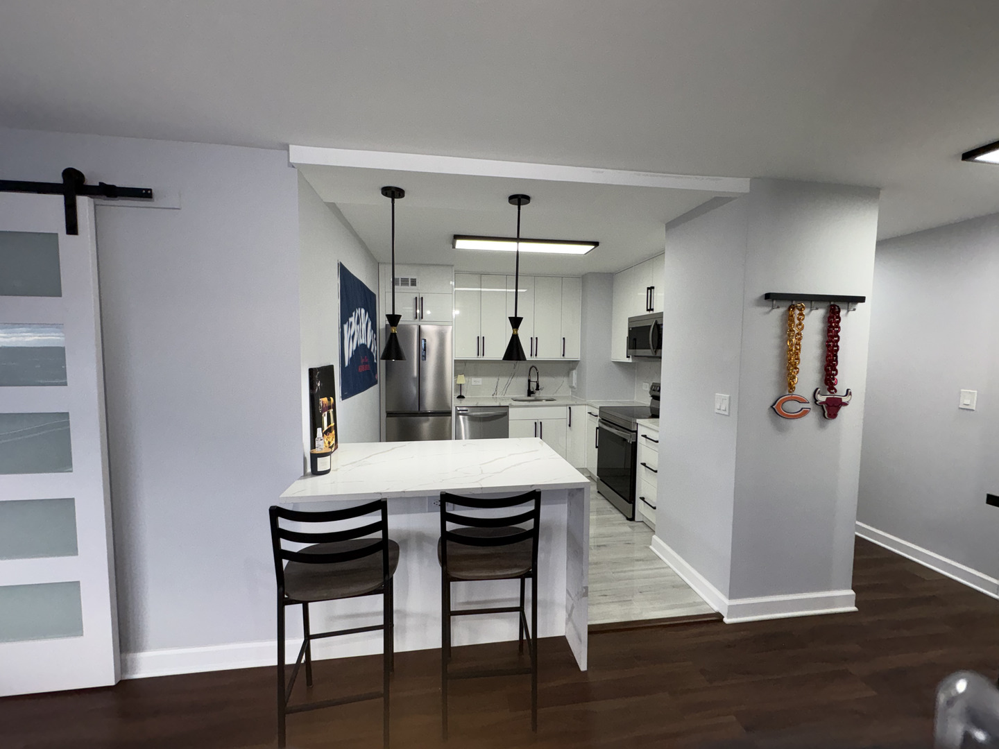 6171 North Sheridan Road, Unit 1102 Chicago, IL 60660 - Photo 15 of 39 a kitchen with stainless steel appliances kitchen island granite countertop a table chairs and a wooden floor
