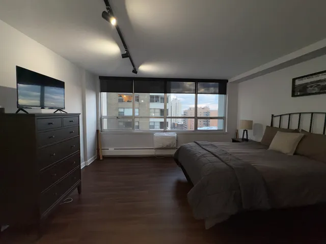 a bedroom with a large bed and a wooden floor