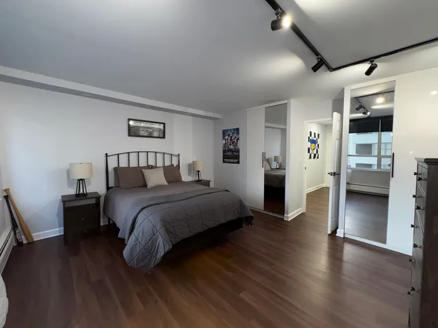 a bedroom with a bed and painting on the wall