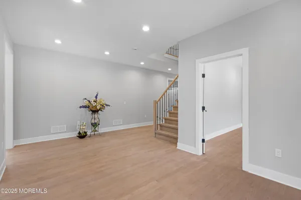 a view of a big room with wooden floor and windows