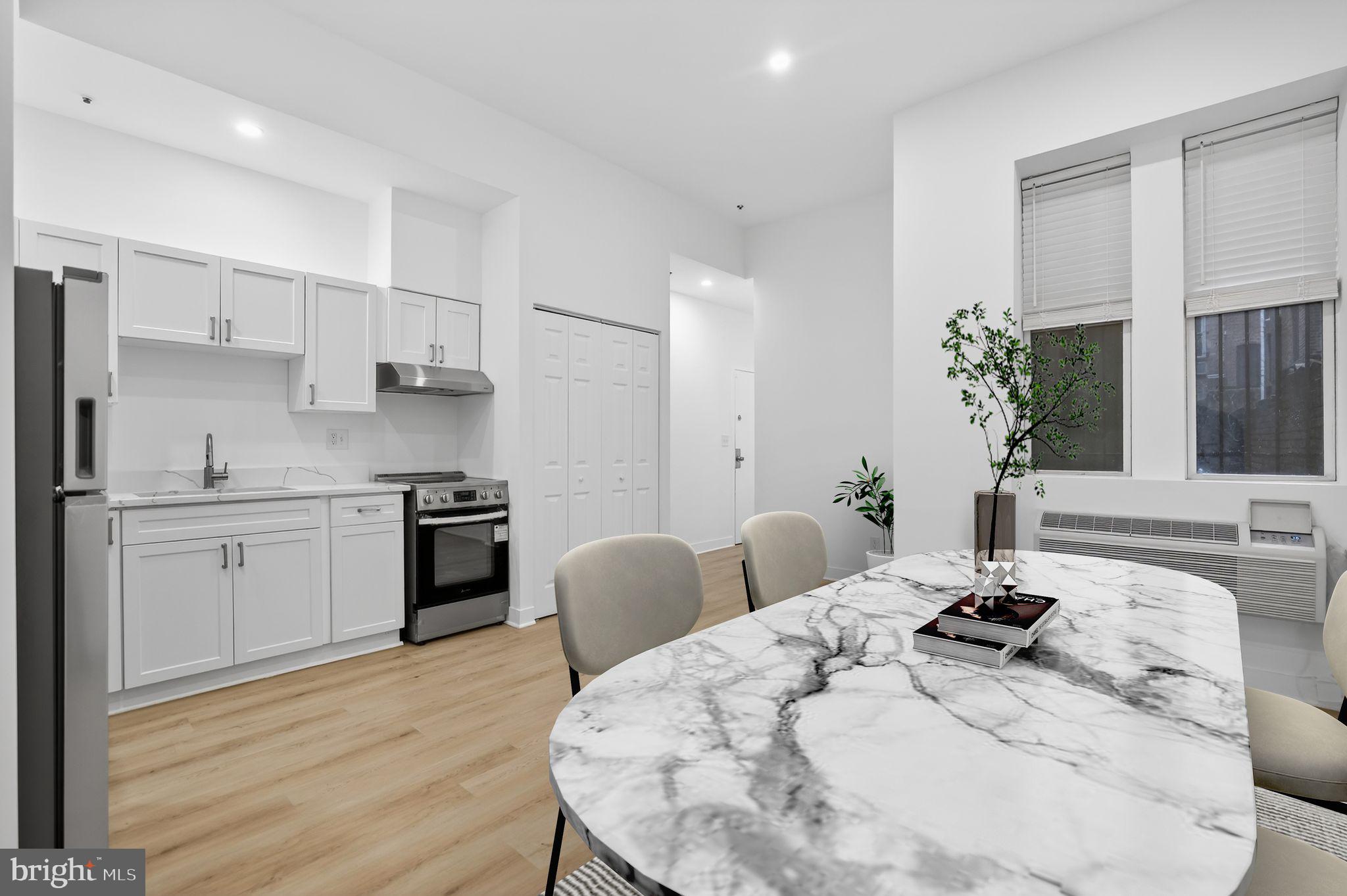 1415 Chapin Street Northwest, Unit 108 Washington, DC 20009 - Photo 3 of 12 a kitchen with stainless steel appliances kitchen island granite countertop a sink a stove a dining table and chairs
