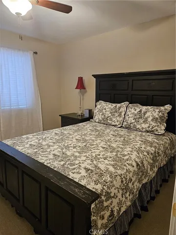a bed sitting in a bedroom next to a wooden cabinet