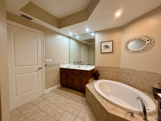 a bathroom with a tub a sink and a mirror