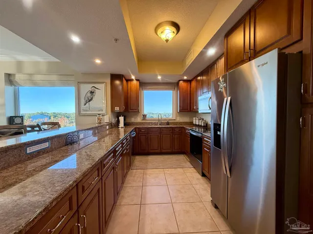 a large kitchen with a large counter top stainless steel appliances and cabinets