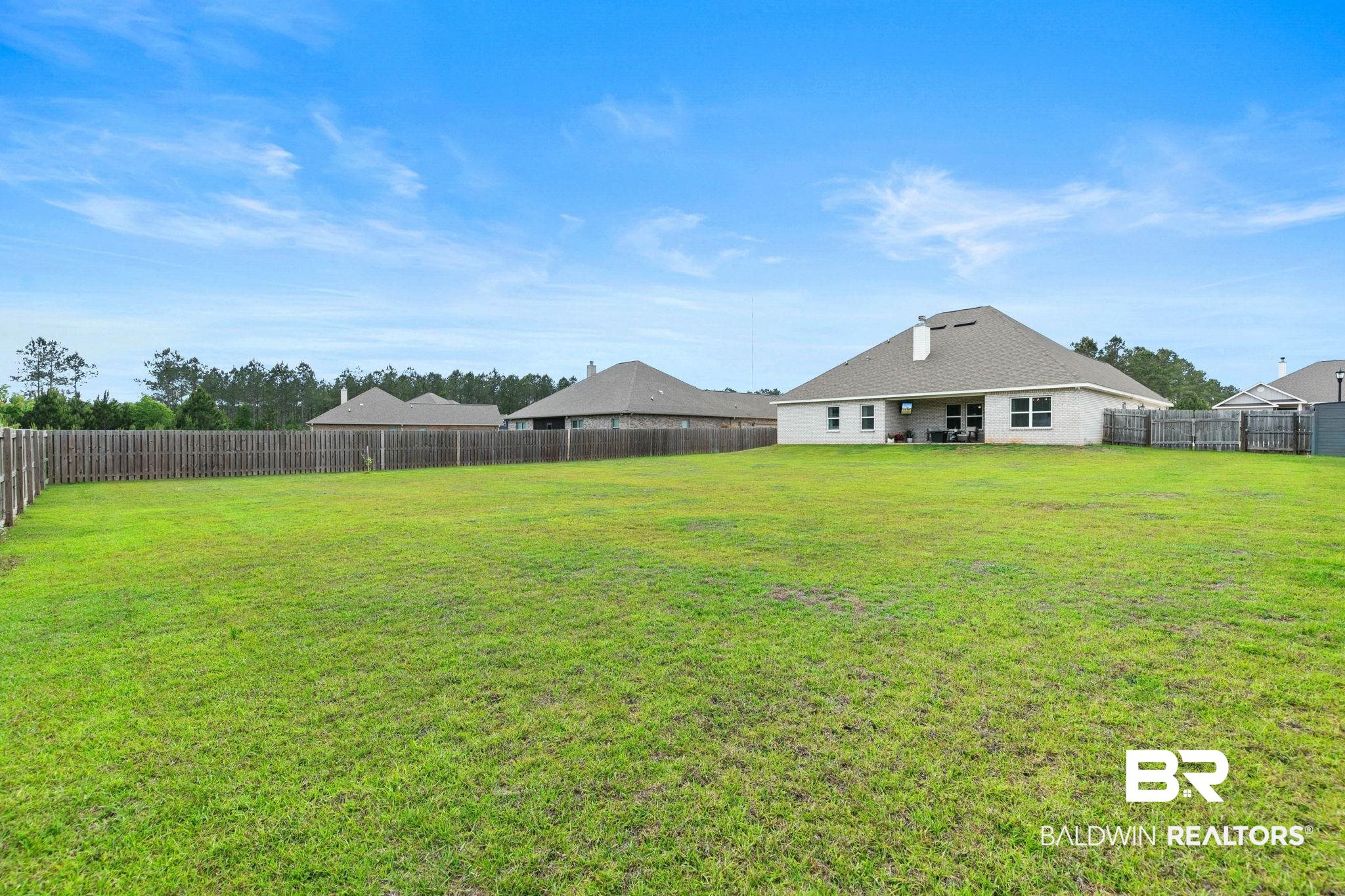 31187 Spoonbill Road Daphne, AL 36527 - Photo 49 of 85 Expansive grass lawn bordered by a wood privacy fence