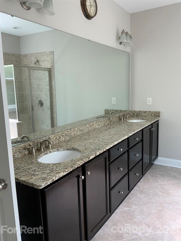 3028 Fallondale Road, Unit 894 Waxhaw, NC 28173 - Photo 11 of 27 a bathroom with a granite countertop sink and a mirror