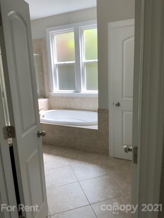 3028 Fallondale Road, Unit 894 Waxhaw, NC 28173 - Photo 14 of 27 a bathroom with a bathtub and next to a window