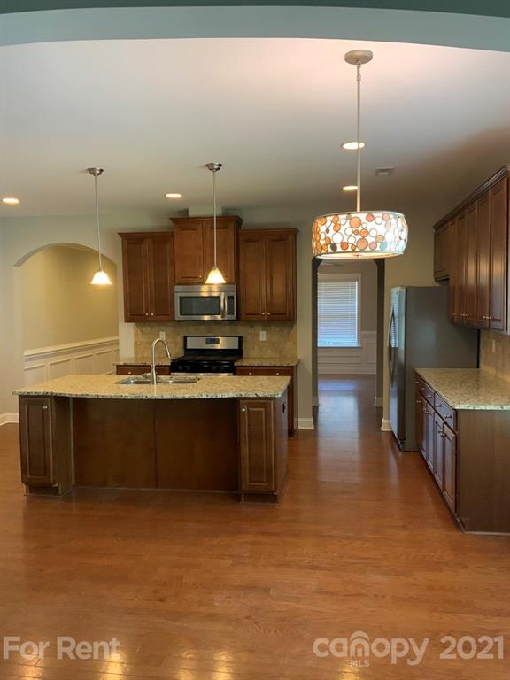 3028 Fallondale Road, Unit 894 Waxhaw, NC 28173 - Photo 6 of 27 a large kitchen with stainless steel appliances a large counter top a stove and a chandelier