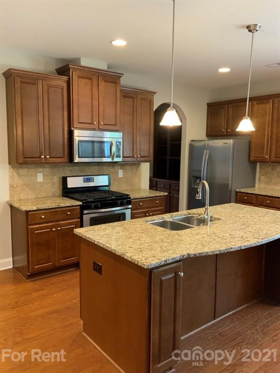 3028 Fallondale Road, Unit 894 Waxhaw, NC 28173 - Photo 8 of 27 a kitchen with kitchen island granite countertop a stove and a sink
