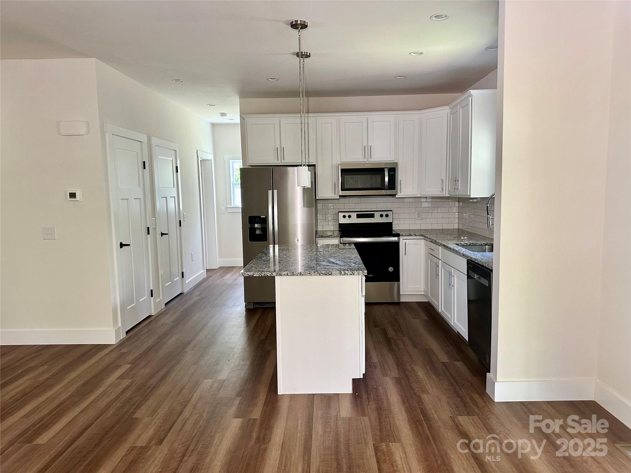 206 Cascade Rdg Road Fairview, NC 28730 - Photo 11 of 38 a kitchen with stainless steel appliances a refrigerator stove microwave and cabinets