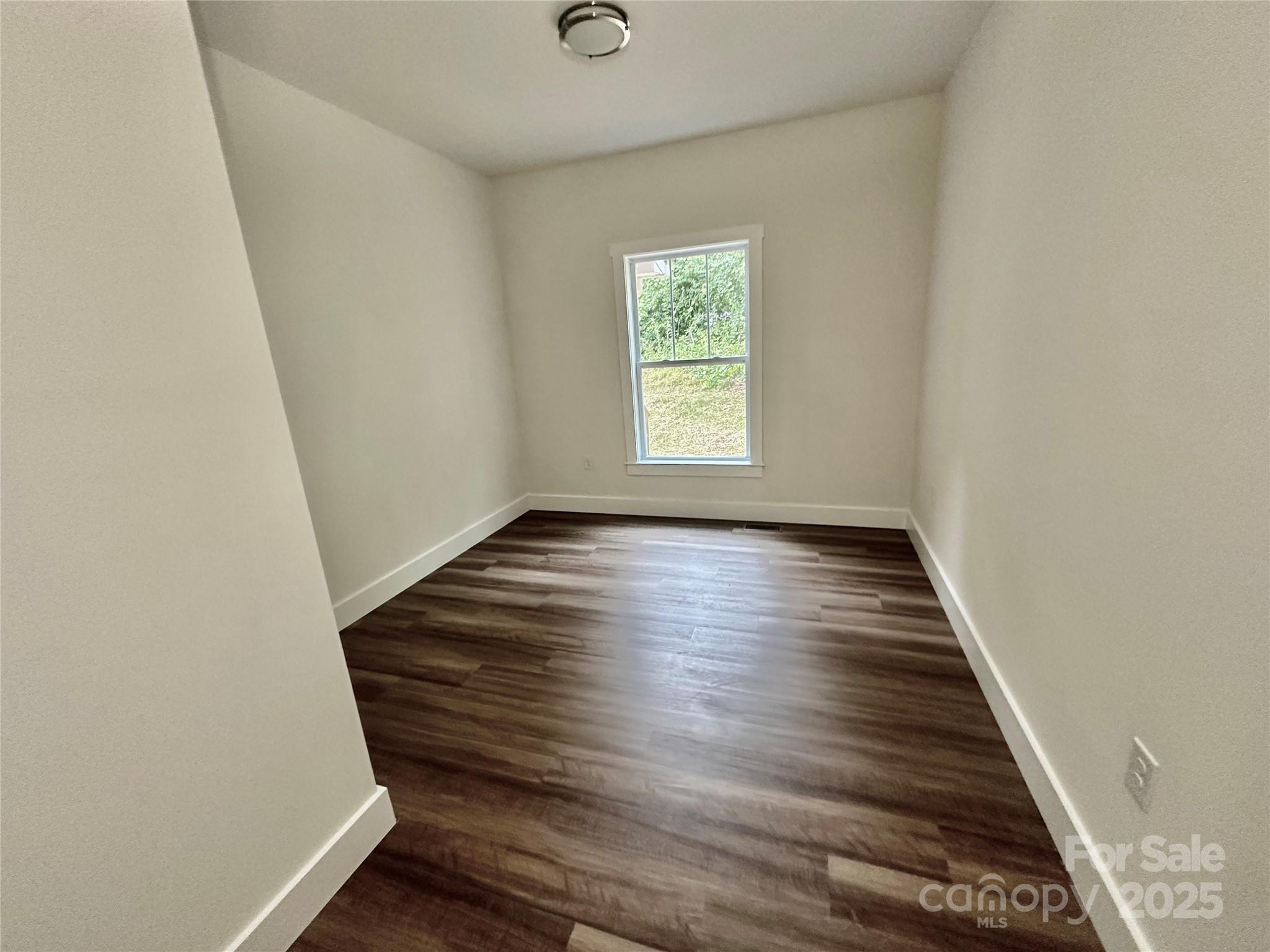 206 Cascade Rdg Road Fairview, NC 28730 - Photo 19 of 38 a view of an empty room with wooden floor and a window