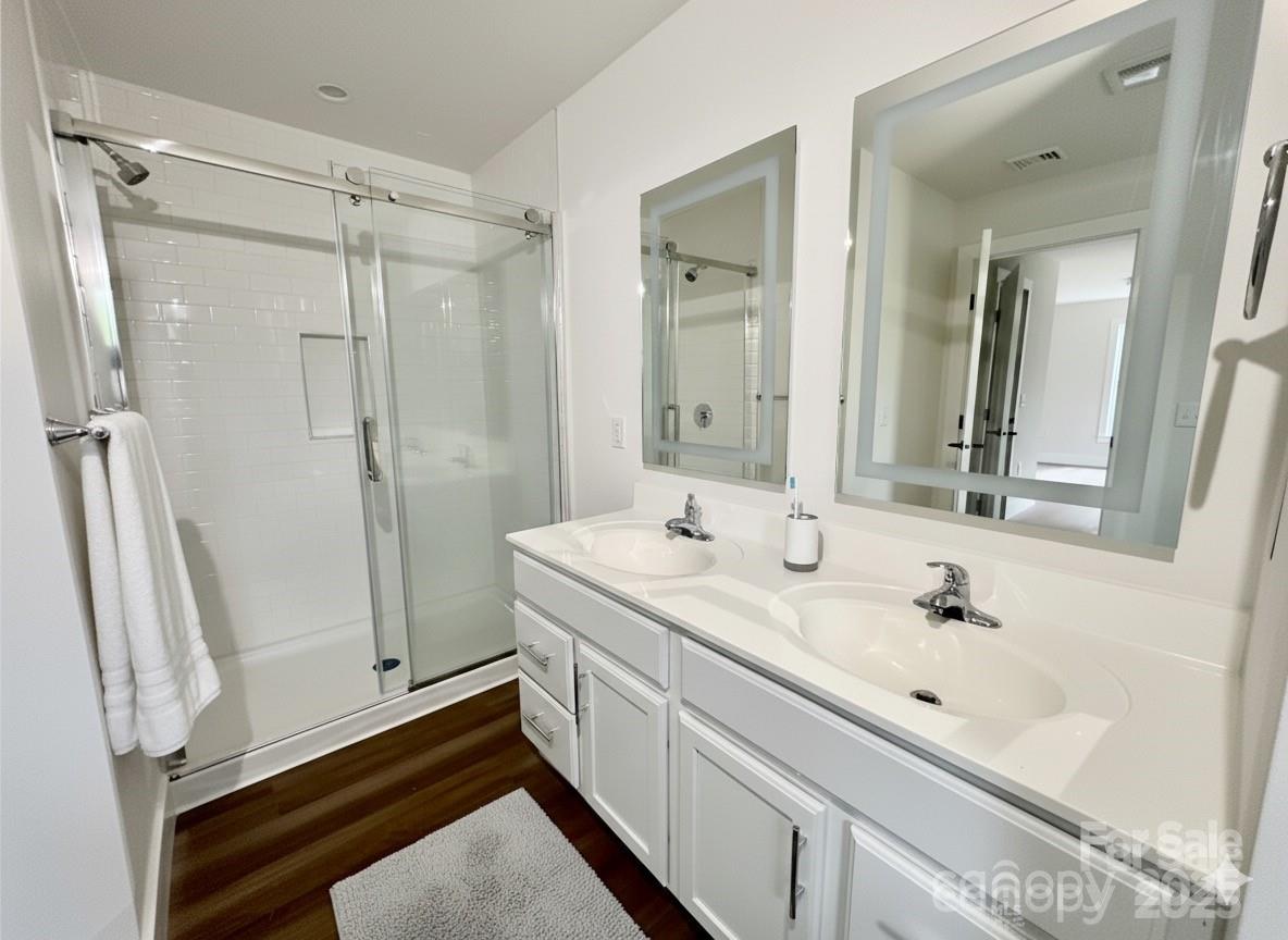 206 Cascade Rdg Road Fairview, NC 28730 - Photo 28 of 38 a bathroom with a sink a mirror a vanity and a shower