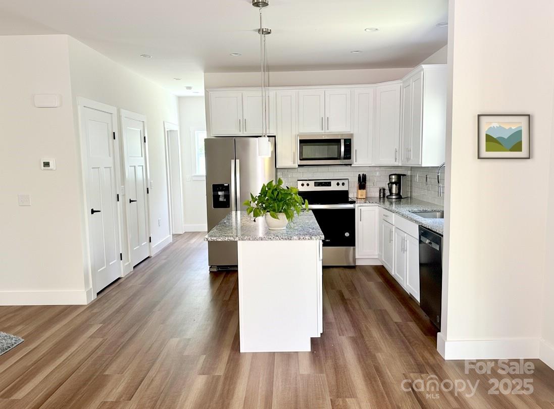 206 Cascade Rdg Road Fairview, NC 28730 - Photo 6 of 38 a large kitchen with cabinets wooden floor a stainless steel appliances and a window