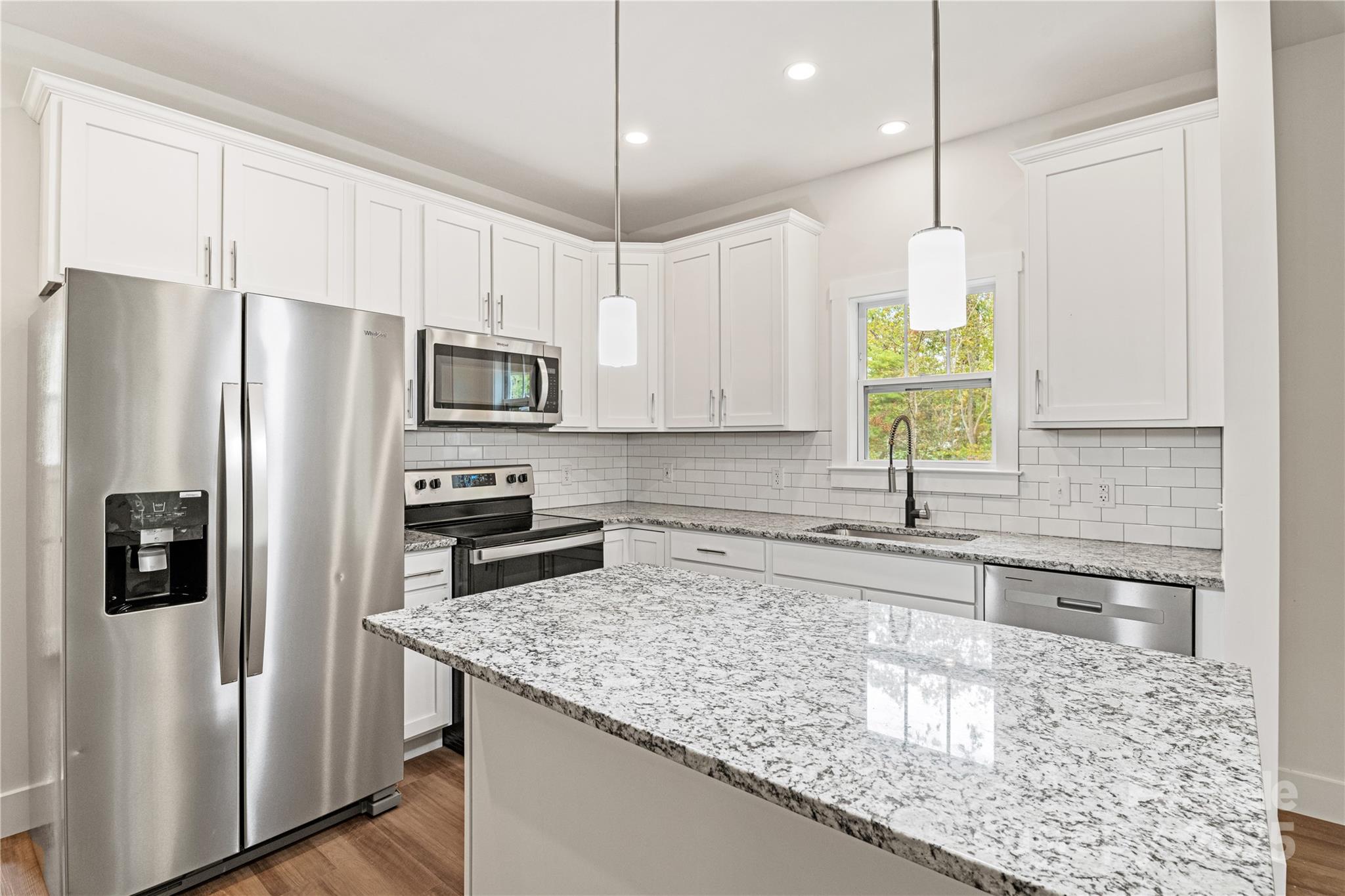 206 Cascade Rdg Road Fairview, NC 28730 - Photo 7 of 38 a kitchen with granite countertop a sink a center island stainless steel appliances and cabinets