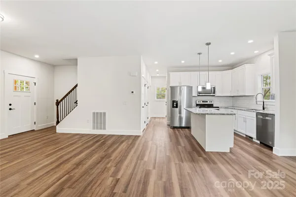 a large kitchen with a lot of counter space and stainless steel appliances