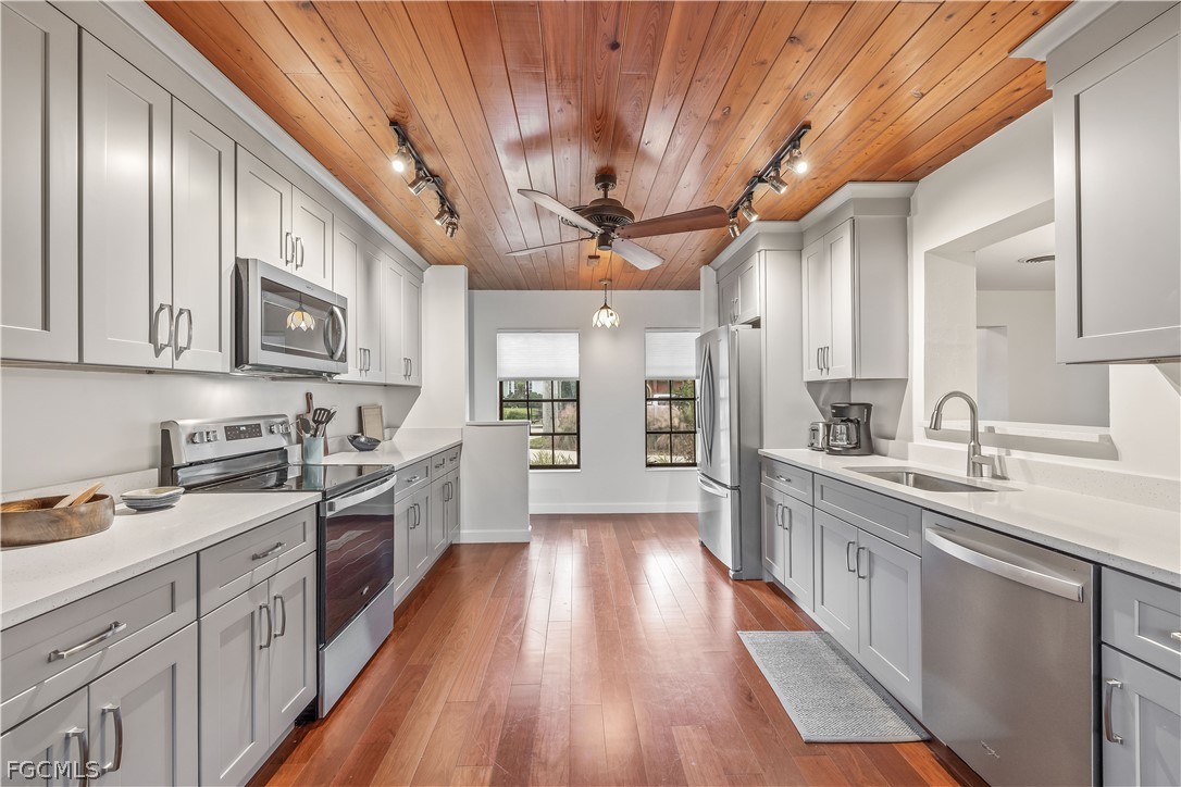 3209 West Riverside Drive Fort Myers, FL 33901 - Photo 10 of 31 a large kitchen with stainless steel appliances granite countertop a lot of counter space and wooden floors
