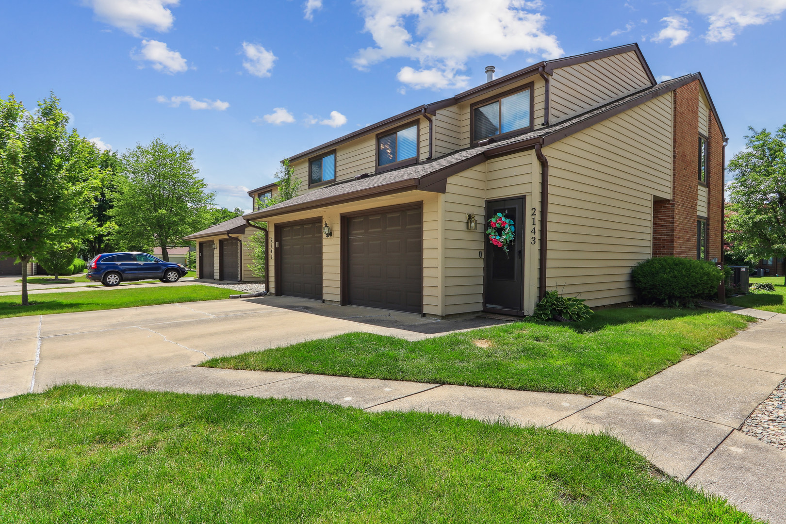a view of a house with a yard and large trees