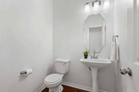 a bathroom with a sink toilet and a mirror