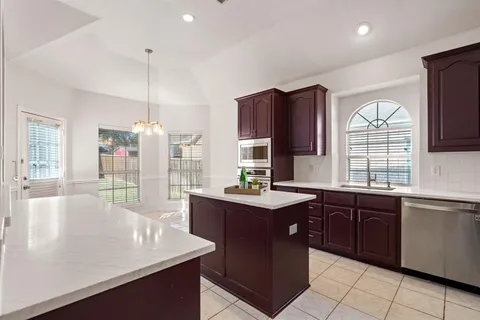 a kitchen with stainless steel appliances granite countertop a sink a stove and a wooden cabinets