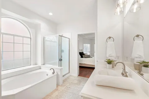 a spacious bathroom with a double vanity sink tub and mirror