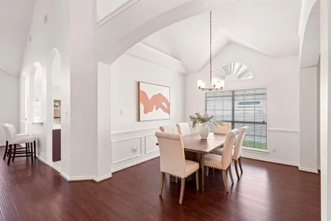 a dining room with furniture a chandelier and wooden floor