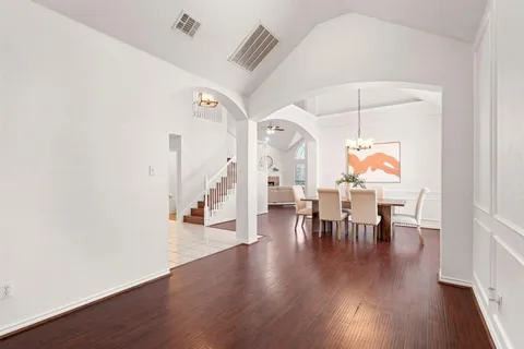 an entryway a dining room and hall with wooden floor