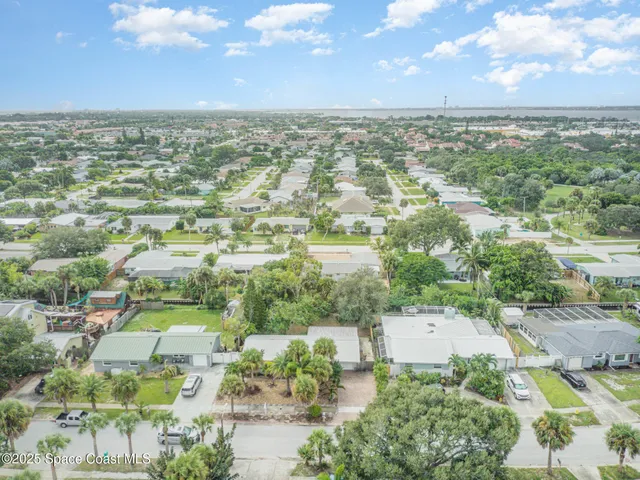 an aerial view of residential houses with outdoor space and trees