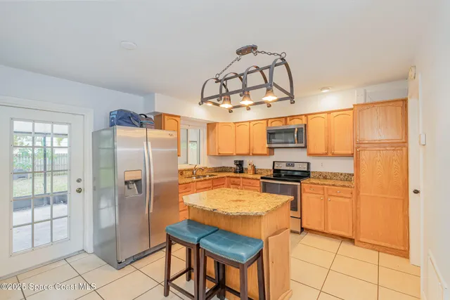 a kitchen with stainless steel appliances granite countertop a refrigerator a stove and a sink