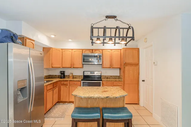 a kitchen with stainless steel appliances granite countertop a stove refrigerator and cabinets