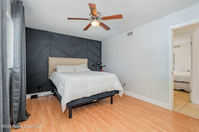 a bedroom with a bed and a ceiling fan