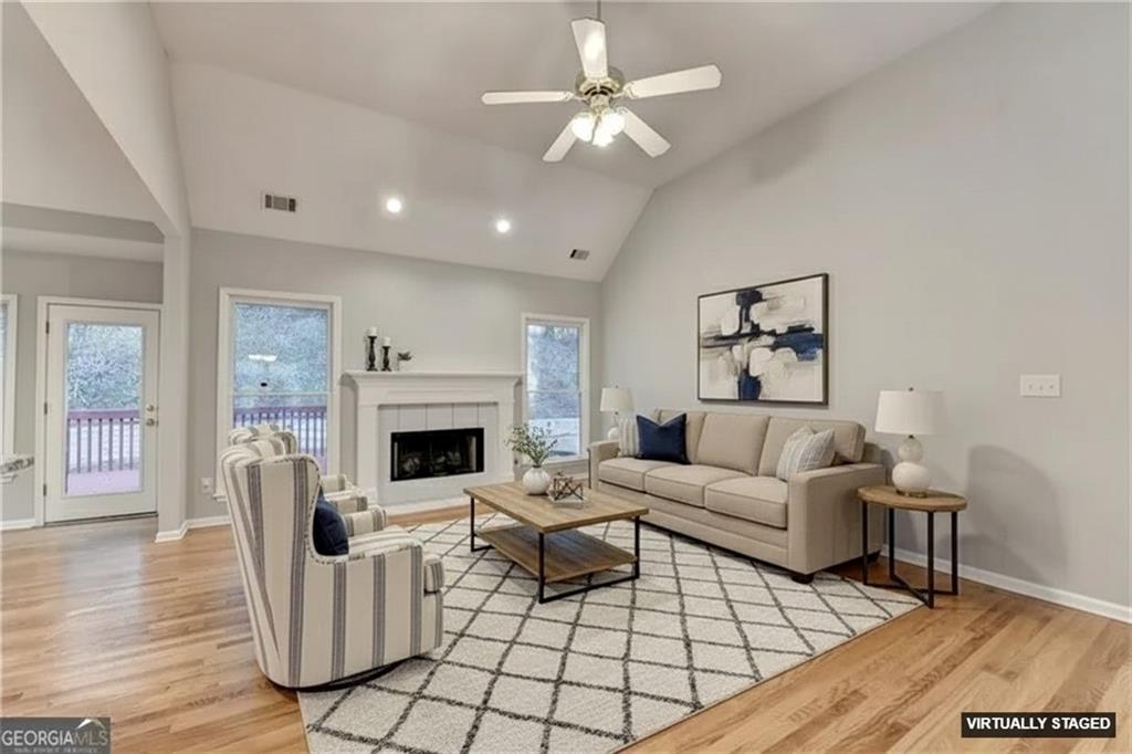655 Golden Meadows Lane Suwanee, GA 30024 - Photo 11 of 72 a living room with furniture a fireplace and wooden floor