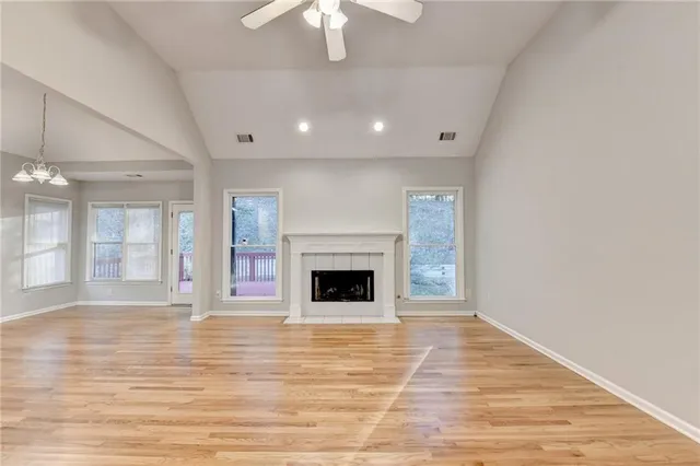 wooden floor fireplace and windows in an empty room