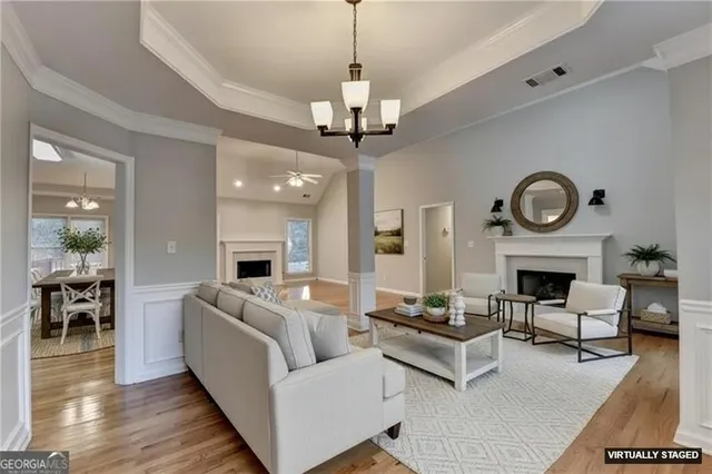 a living room with furniture a fireplace and a chandelier