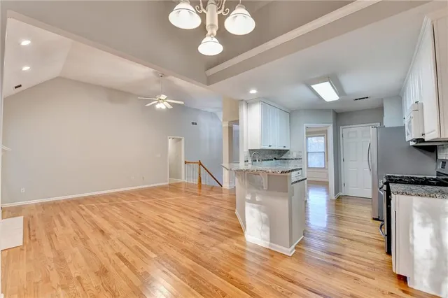 a kitchen with stainless steel appliances granite countertop a stove and a wooden floors