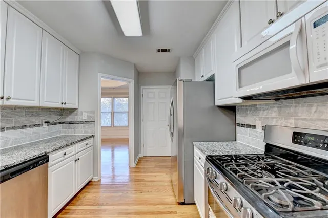a kitchen with granite countertop a sink a stove and cabinets