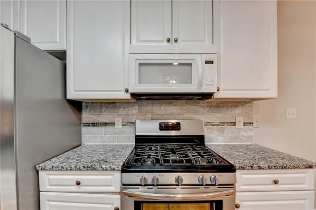 a large kitchen with granite countertop a stove and a sink