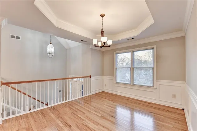 an empty room with windows and chandelier fan