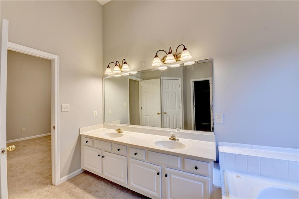 655 Golden Meadows Lane Suwanee, GA 30024 - Photo 35 of 72 a bathroom with a double vanity sink and a mirror