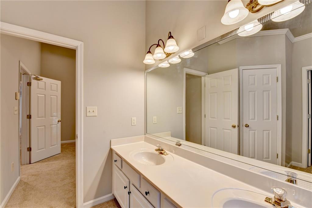 655 Golden Meadows Lane Suwanee, GA 30024 - Photo 36 of 72 a bathroom with a sink a light fixture and a mirror