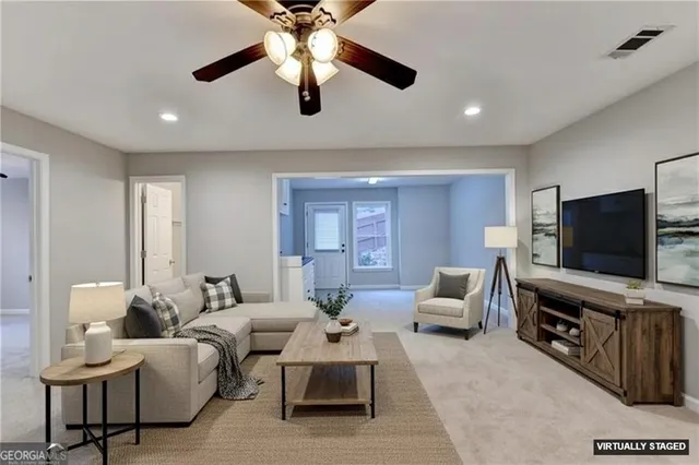 an empty room with a chandelier fan and windows