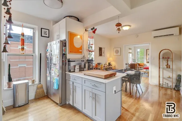 a kitchen with a refrigerator a stove a sink dishwasher and wooden cabinets with wooden floor