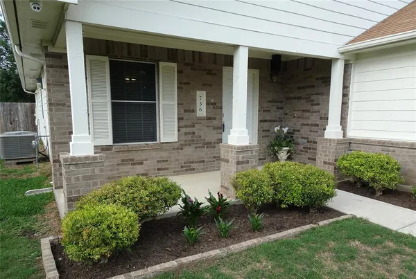 front view of a brick house with a yard