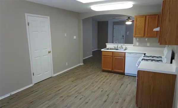 a kitchen with a sink cabinets and wooden floor