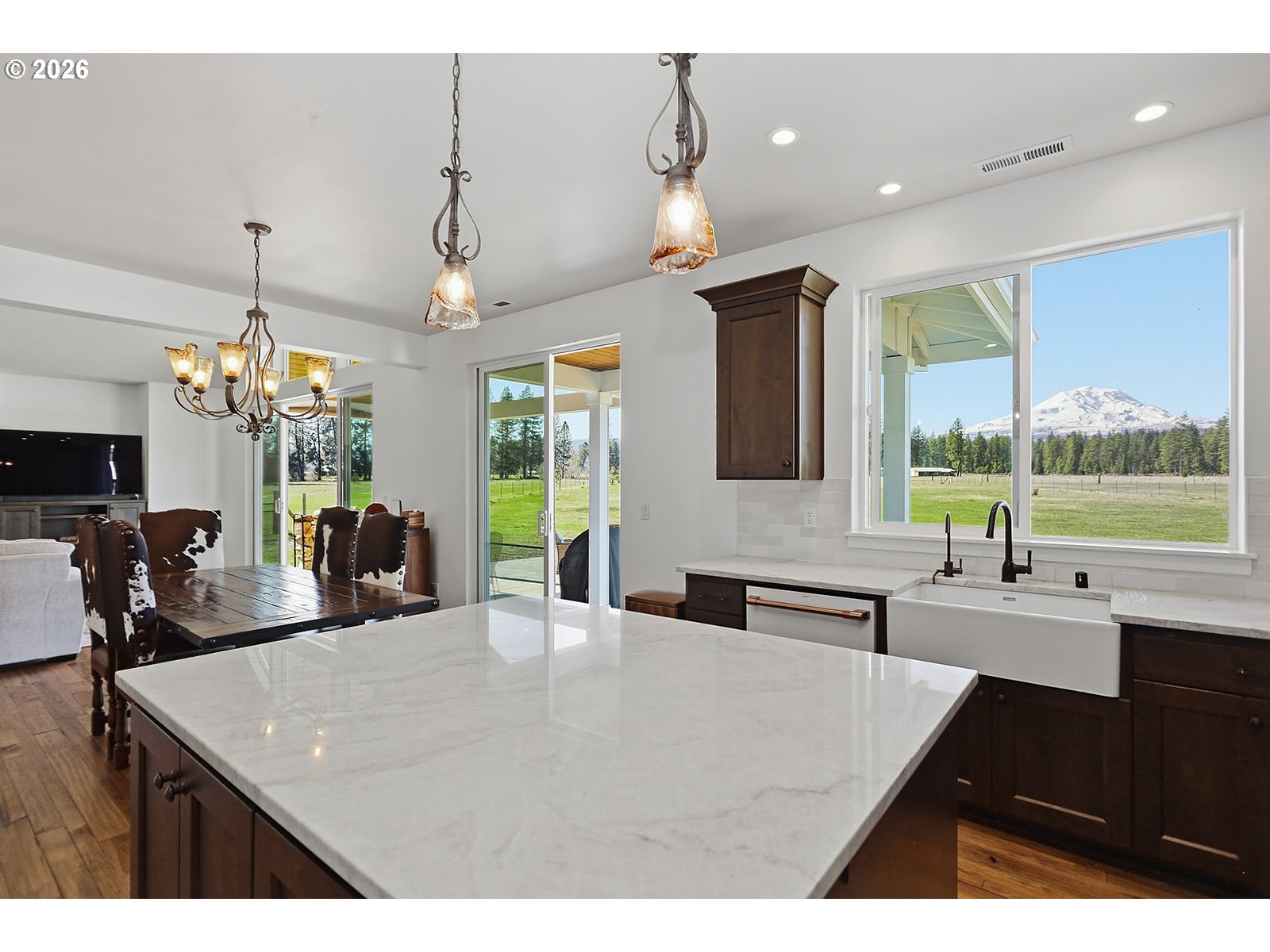 24 Bacon Creek Road Glenwood, WA 98619 - Photo 17 of 48 a kitchen with stainless steel appliances a sink dishwasher a dining table and chairs with wooden floor