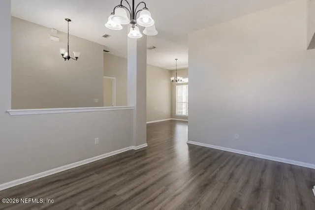 a view of a room with wooden floor and a ceiling fan