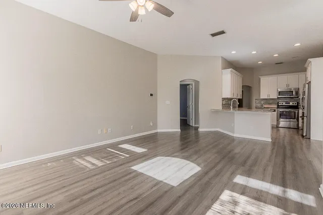 a view of a kitchen with wooden floor and an empty space