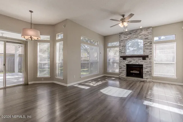 wooden floor fireplace and windows in an empty room